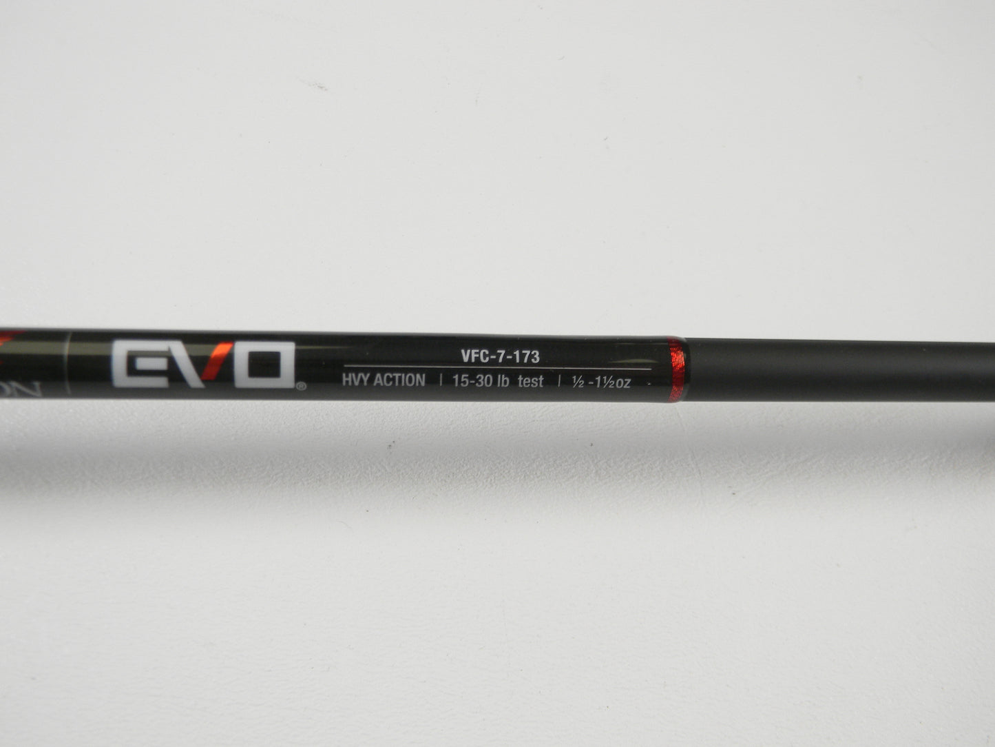 Close-up of a black Falcon EVO casting rod with "VFC-7-173," "HVY ACTION," and line weight specs "15-30 lb test, 1/2 - 1 1/2 oz" text in white and red. Perfect for our Rod and Reel Trade-In Program, even if used. Photographed against a white background.