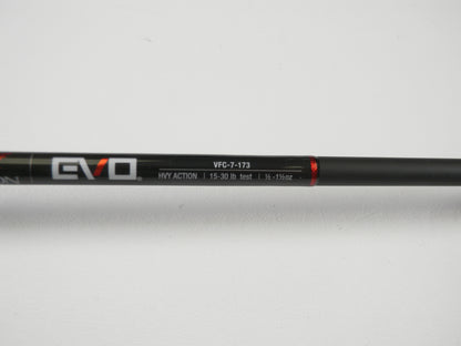 Close-up of a black Falcon EVO casting rod with "VFC-7-173," "HVY ACTION," and line weight specs "15-30 lb test, 1/2 - 1 1/2 oz" text in white and red. Perfect for our Rod and Reel Trade-In Program, even if used. Photographed against a white background.