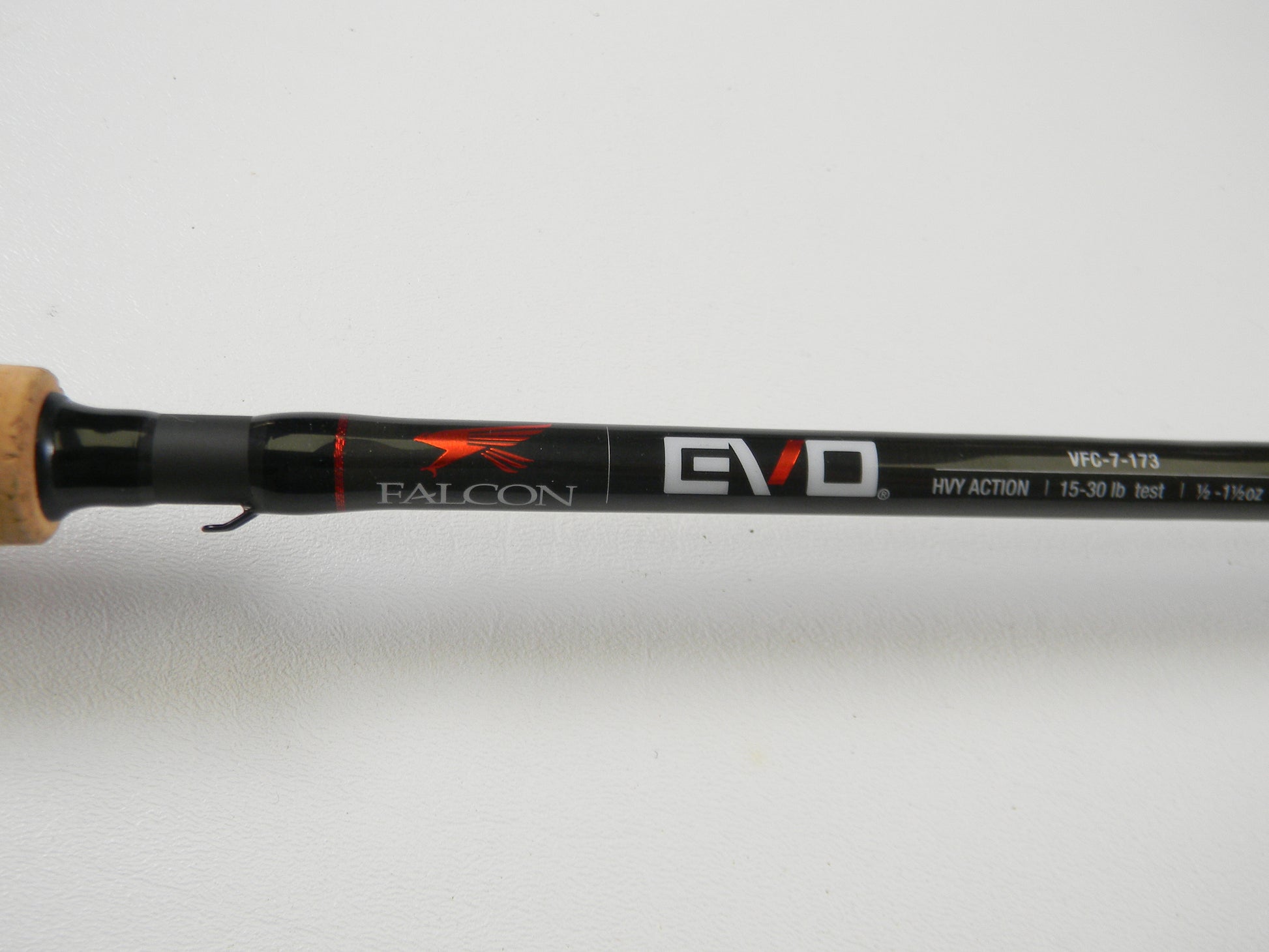 Close-up of the Falcon EVO VFC-7-173 7'3" Heavy casting rod with "HVY ACTION" and line weight details. It features a cork grip and sleek black finish, ideal for upgrading anglers. Qualifies for Rod and Reel Trade-In Program to earn store credit on used gear.