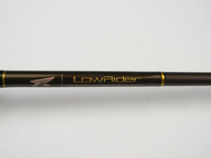 Close-up of the Falcon Lowrider LFC-72HH Flippin Stik 7'2" Heavy in black with gold accents, featuring "LowRider" and an eagle logo. Perfect for trade-in programs, this rod offers anglers store credit on used gear. Set against a plain white surface, it highlights its sleek design.