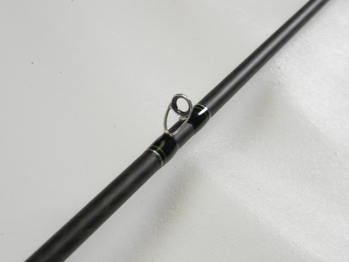 Close-up of a Phenix Maxim PHX-MAX-C610MH 6'10" Medium Heavy casting rod in excellent condition, showcasing the guide ring with black and green wraps. Perfect for our Rod and Reel Trade-In Program—exchange your used gear for store credit today.
