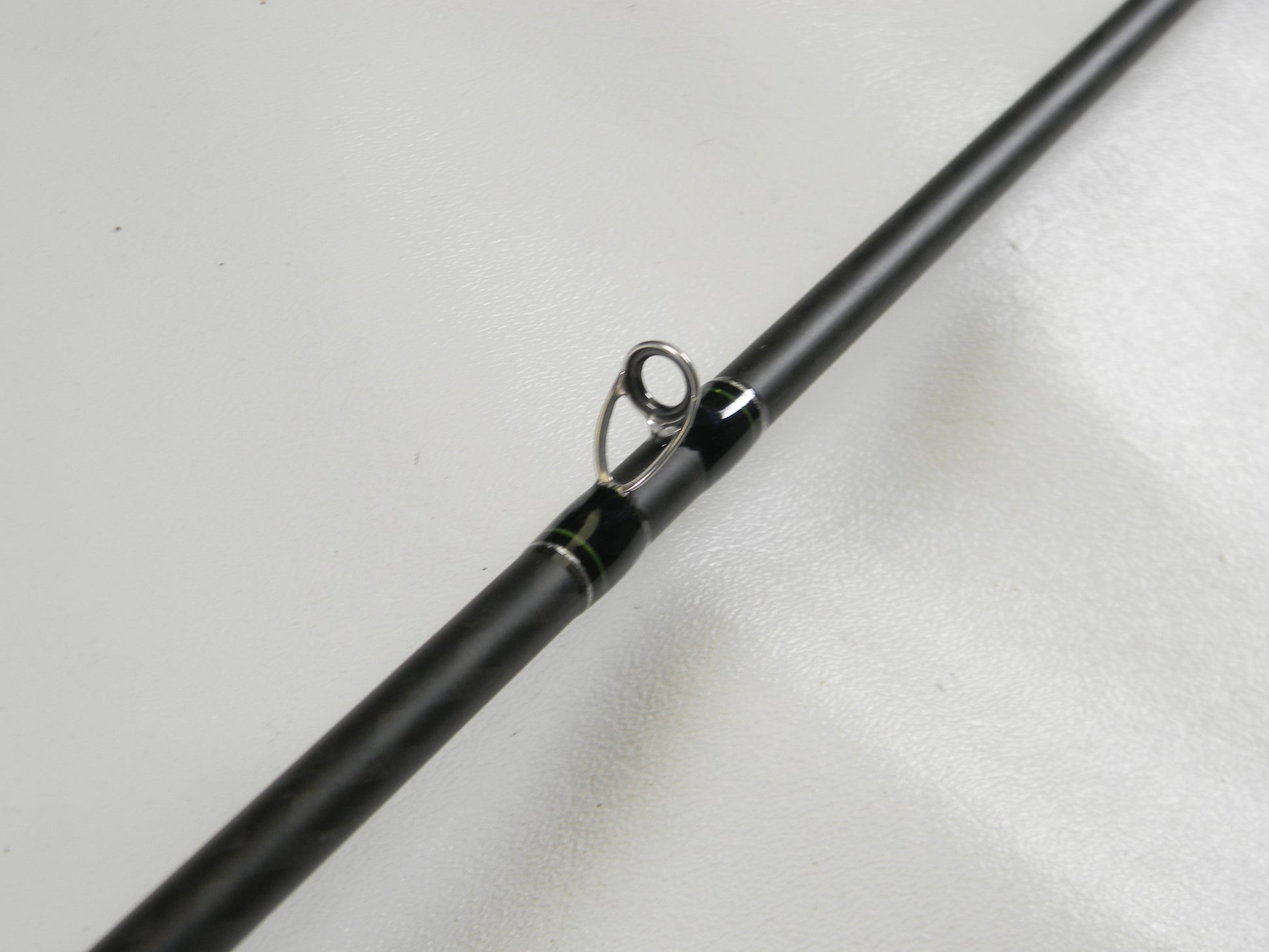 Close-up of a Phenix Maxim PHX-MAX-C610MH 6'10" Medium Heavy casting rod in excellent condition, showcasing the guide ring with black and green wraps. Perfect for our Rod and Reel Trade-In Program—exchange your used gear for store credit today.