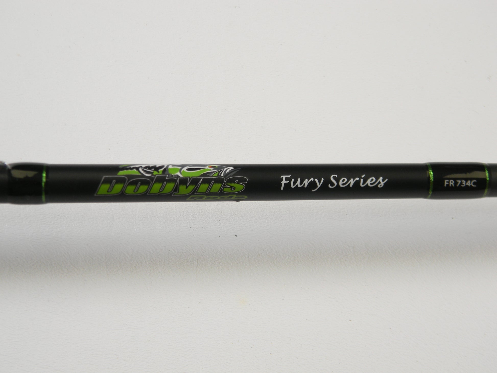 Close-up of a black Dobyns Fury FR734C Used Casting Rod with green accents, displaying the text "Dobyns Fury Series FR 734C" against a white background.