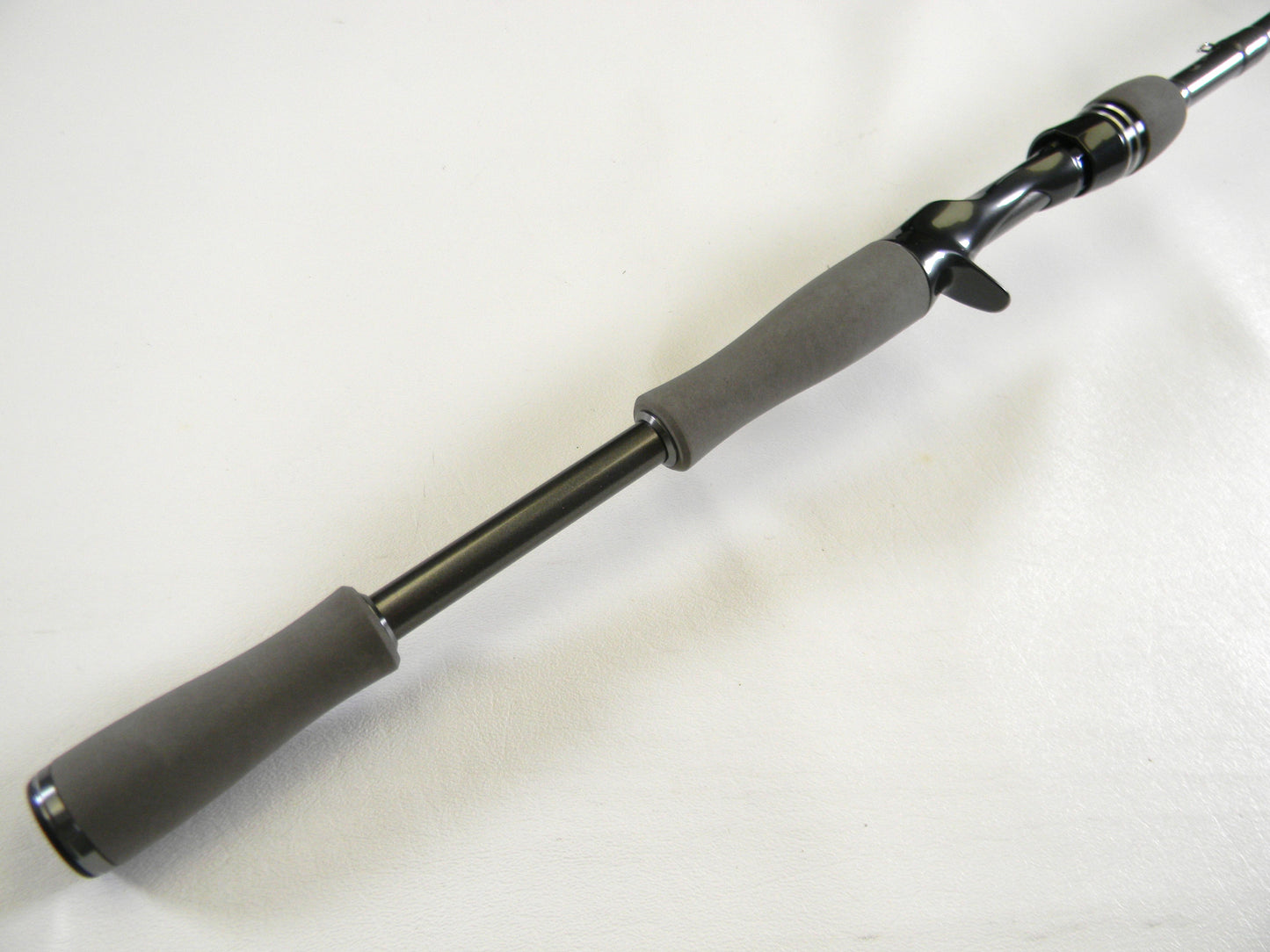Close-up of the Daiwa Tatula Elite TTEL731HFB casting rod handle on a white background. The sleek, black design includes gray ergonomic grips and a trigger grip seat for comfort. Trade in your old gear via our Rod and Reel Trade-In Program to get store credit for an upgrade.
