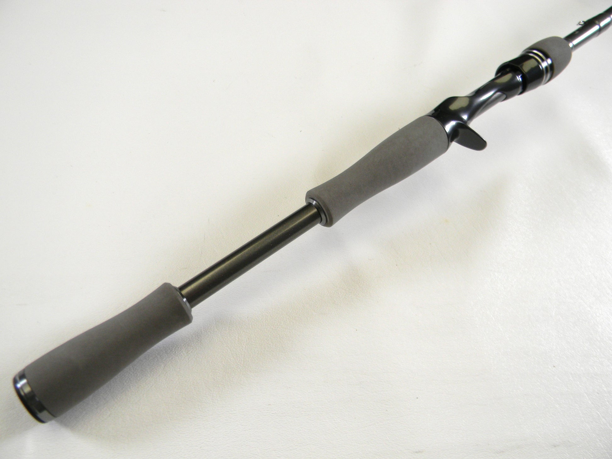 Close-up of the Daiwa Tatula Elite TTEL731HFB casting rod handle on a white background. The sleek, black design includes gray ergonomic grips and a trigger grip seat for comfort. Trade in your old gear via our Rod and Reel Trade-In Program to get store credit for an upgrade.