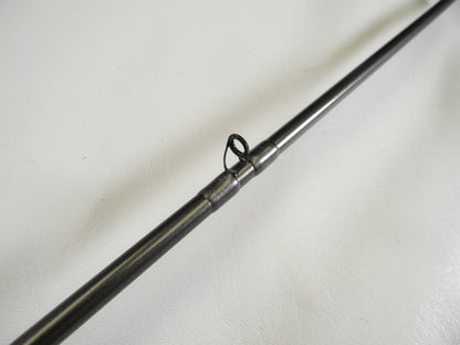 Close-up of a Daiwa Tatula Elite TTEL731HFB used casting rod's metal guide from our Trade-In Program. This circular loop directs the line along the rod's smooth metallic surface, set against a white background.