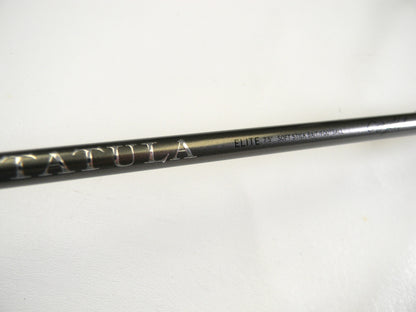 Close-up of a Daiwa Tatula Elite TTEL751MHFB fishing rod with metallic branding, featured in our Rod and Reel Trade-In Program. Its sleek dark finish on the 7'5" medium heavy rod is highlighted against a plain white background, showcasing its premium design.