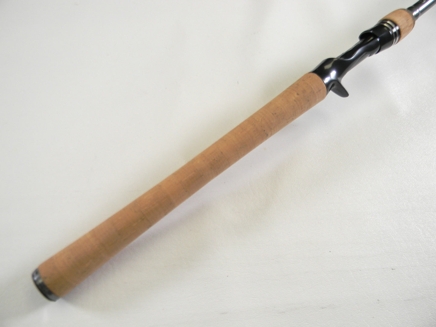 Close-up of the Daiwa Tatula Elite TTEL751HFB handle with a smooth cork grip and black reel seat. Perfect for a Rod and Reel Trade-In to refresh used gear, this mint condition 7'5" heavy casting rod stands out against the white background.