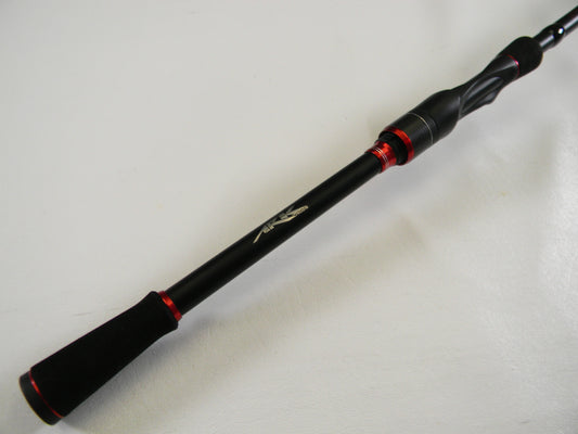 Close-up of the Ark Invoker Pro IVP71MXS 7'1" Medium Used Spinning Rod in black with red accents and ergonomic grip on a white background. This sleek design by Ark Fishing features a logo near the handle. Trade-in with our Rod and Reel Program to earn store credit for your next purchase.