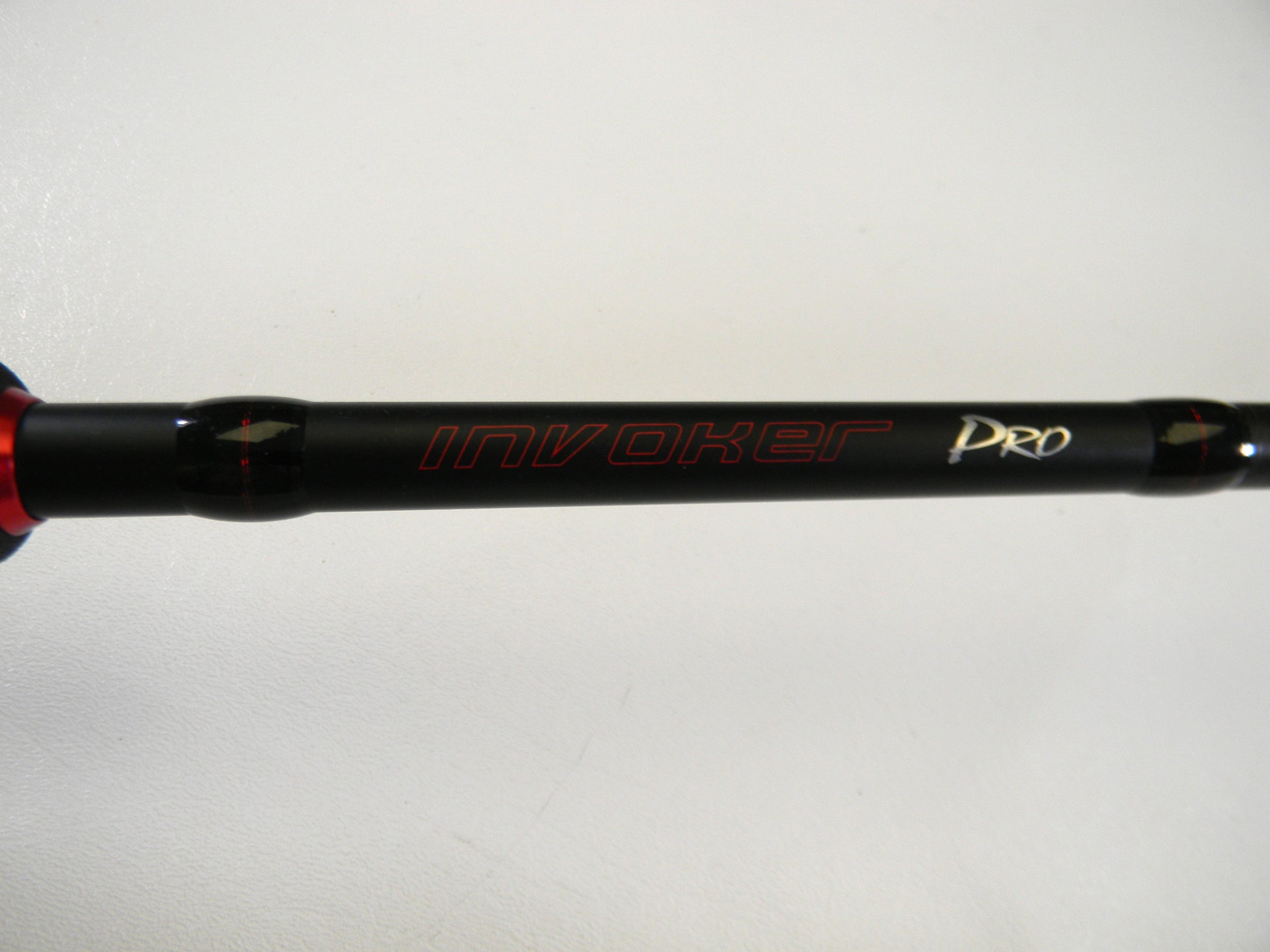 Close-up of a black Ark Fishing rod, model Invoker Pro IVP71MXS 7'1" Medium, with red and white lettering on a white background. Upgrade now with our Rod and Reel Trade-In Program to convert used gear into valuable store credit.