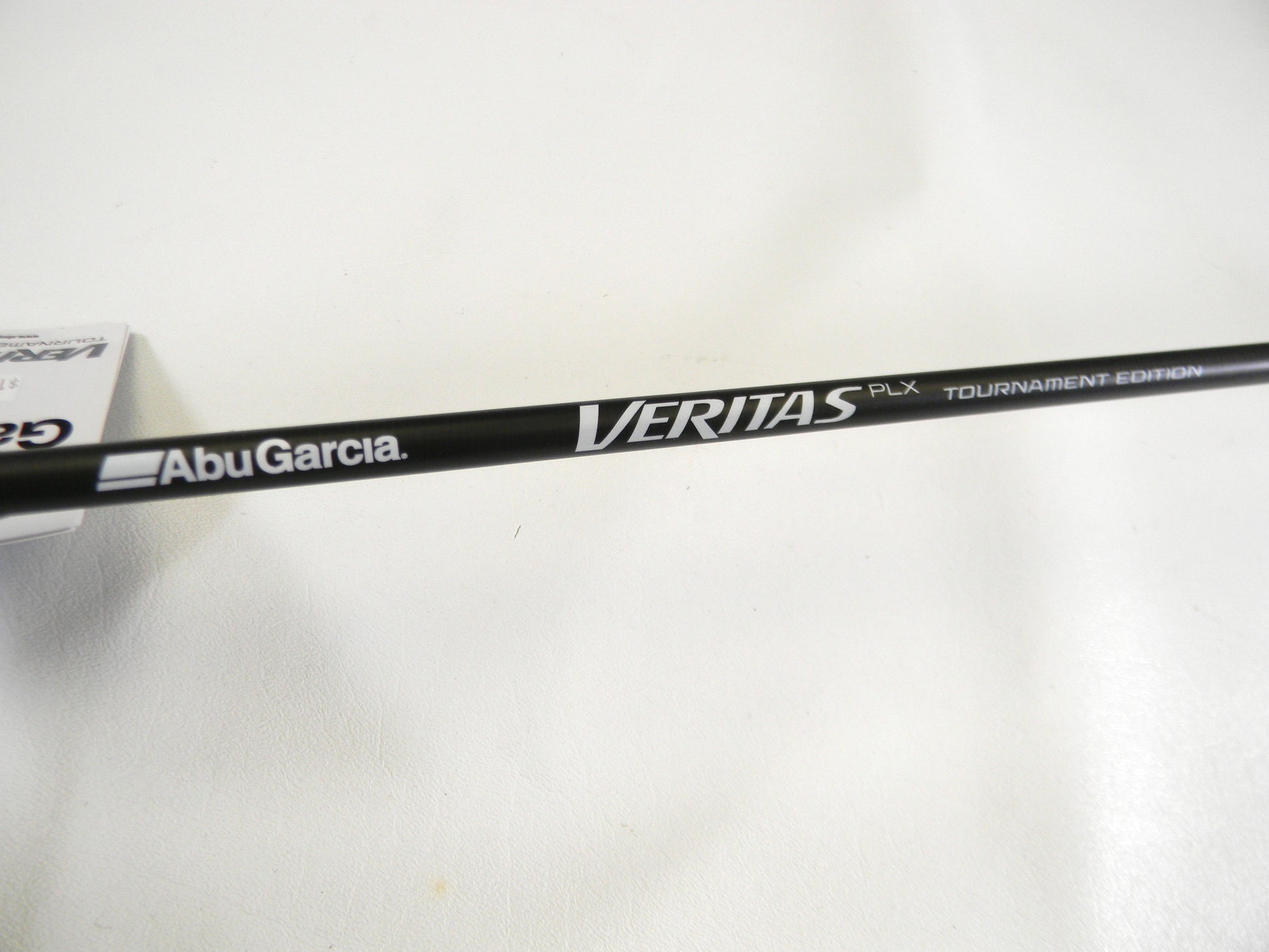 Close-up of a black fishing rod with "Abu Garcia" and "Veritas Tournament VXTC72-5" text on a white backdrop, ideal for our Rod and Reel Trade-In program for store credit.