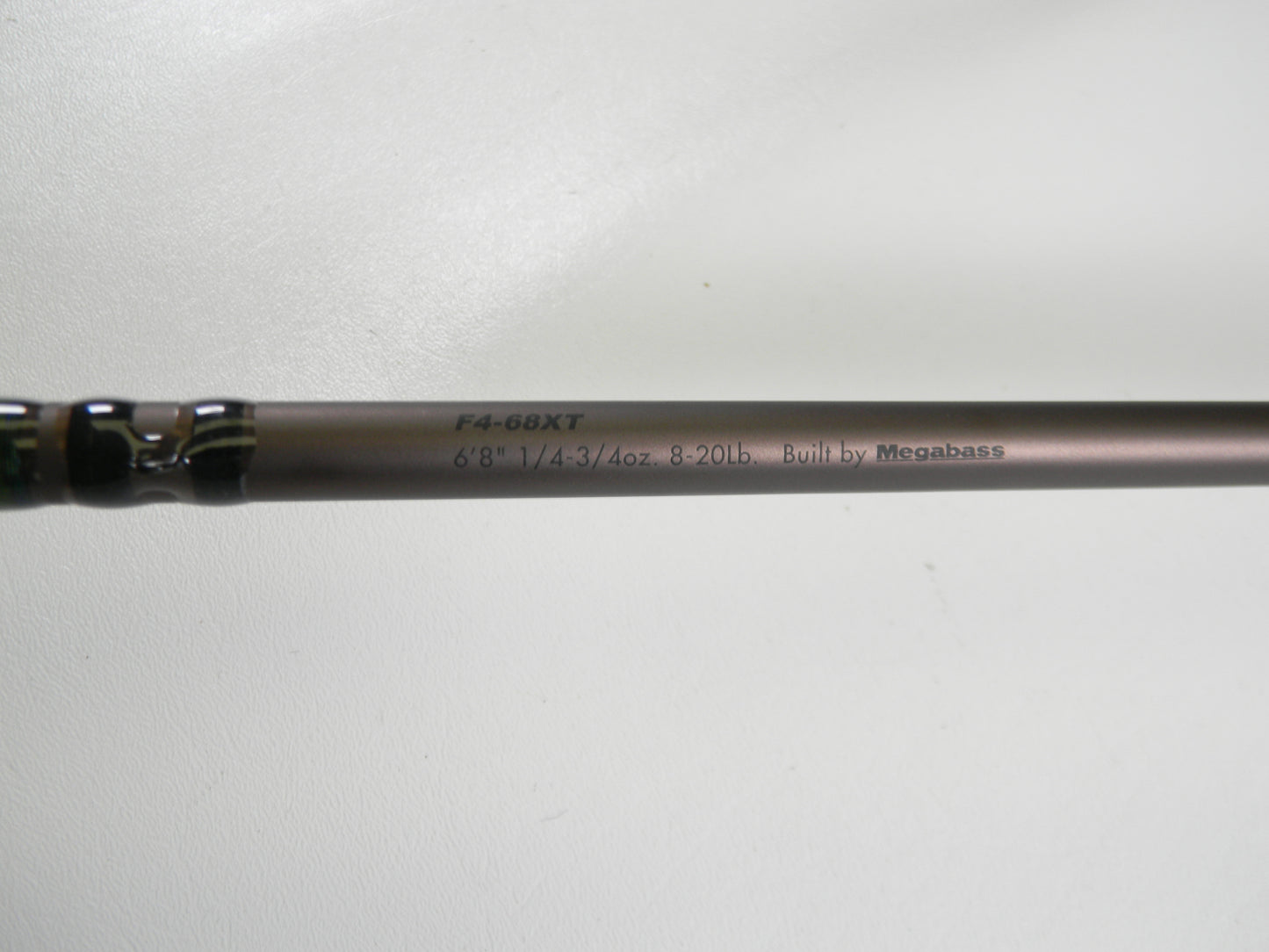 A close-up of the Megabass Orochi X10 F4-68XT Jabberwock 6'8" Medium Light Used Casting Rod (Excellent Condition), eligible for our Rod and Reel Trade-In Program, rests on a plain white surface.