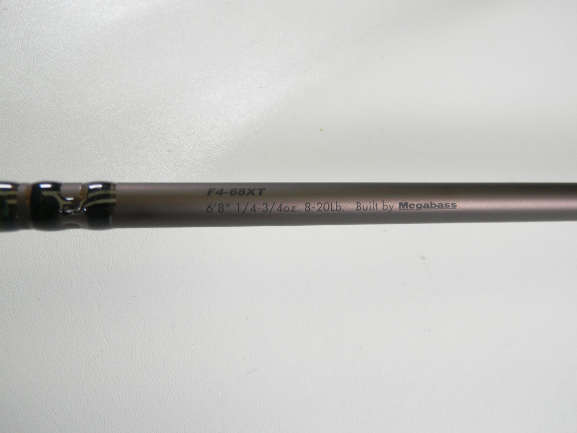 A close-up of the Megabass Orochi X10 F4-68XT Jabberwock 6'8" Medium Light Used Casting Rod (Excellent Condition), eligible for our Rod and Reel Trade-In Program, rests on a plain white surface.