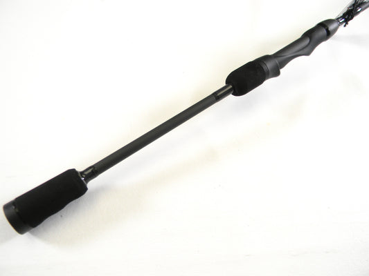 Close-up of the Abu Garcia Veritas Tournament VXTS610-4 spinning rod in mint condition on a white background. Ideal for trading in used gear, this sleek black rod with a smooth handle and cylindrical grip can earn you credit through our Rod and Reel Trade-In program.