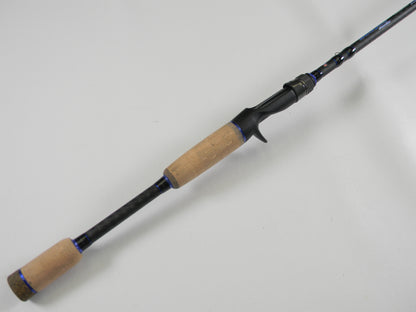 A Dobyns Champion XP DC705C 7'0" Mag Heavy Casting Rod with cork handle and black reel seat is shown on a white background—ideal for upgrading via our Rod and Reel Trade-In Program.