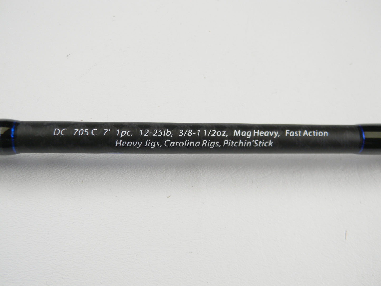 A close-up of the Dobyns Champion XP DC705C 7'0" Mag Heavy Used Casting Rod in excellent condition, with specs in white on a black rod—ideal for anglers using our Rod and Reel Trade-In Program or upgrading for store credit.