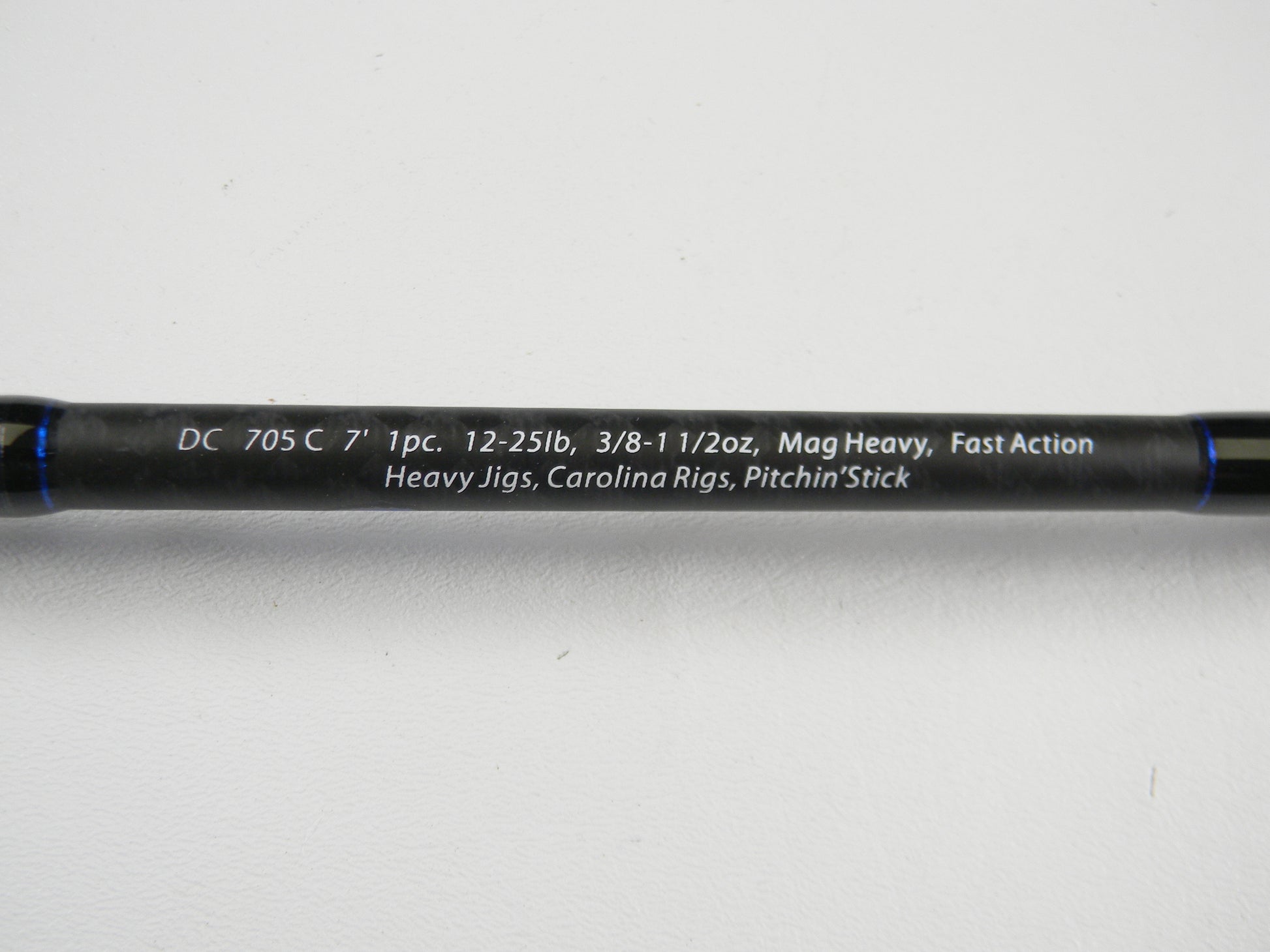 A close-up of the Dobyns Champion XP DC705C 7'0" Mag Heavy Used Casting Rod in excellent condition, with specs in white on a black rod—ideal for anglers using our Rod and Reel Trade-In Program or upgrading for store credit.