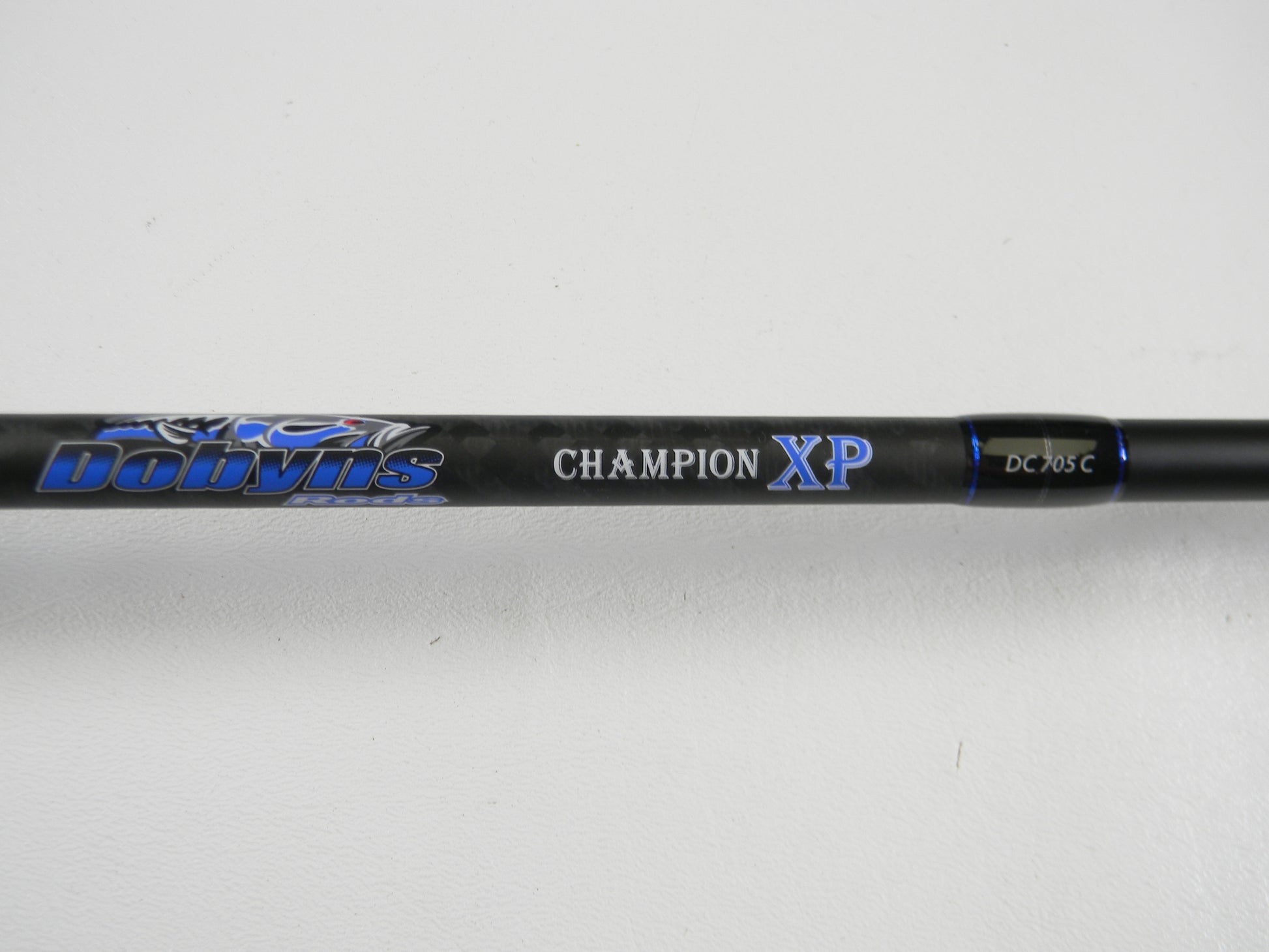 A close-up of a Dobyns Champion XP DC705C 7'0" Mag Heavy Used Casting Rod in excellent condition, featuring blue and white lettering on a black rod, photographed against a white background—ideal for anglers trading up with our Rod and Reel Trade-In Program.