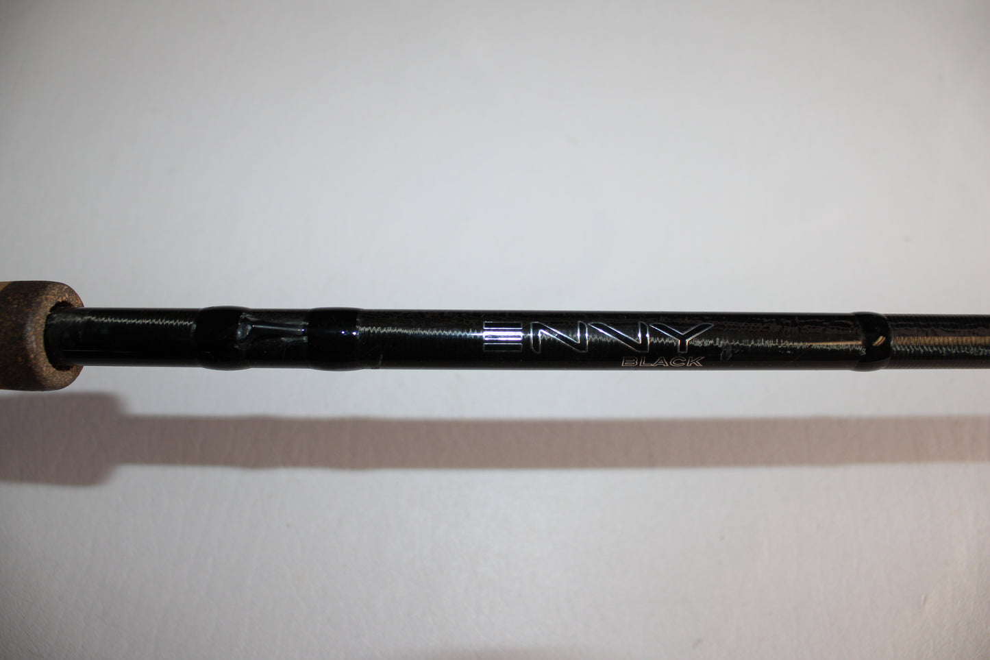 Close-up of a 13 Fishing Envy Black EB3C79C Crank Used Casting Rod in good condition, featuring "ENVY" and "BLACK" in silver lettering on its black body. The background is plain white.