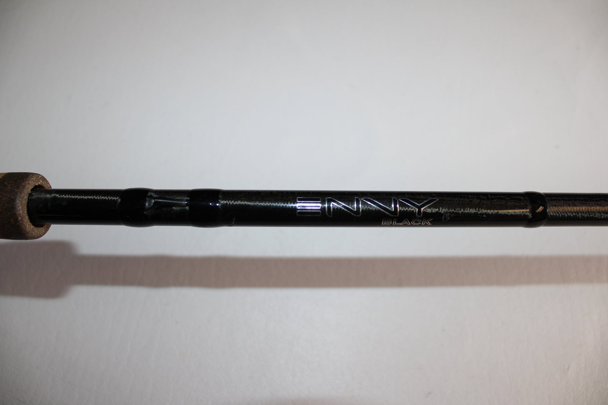 Close-up of a 13 Fishing Envy Black EB3C79C Crank Used Casting Rod in good condition, featuring "ENVY" and "BLACK" in silver lettering on its black body. The background is plain white.