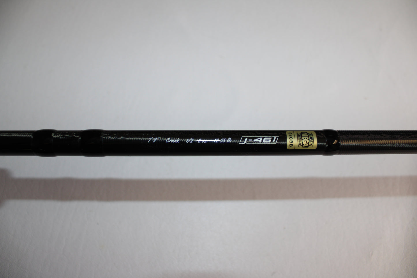 A close-up of a 13 Fishing Envy Black EB3C79C Crank casting rod in good used condition, featuring metallic "j-46T" text and a gold label on a white background.
