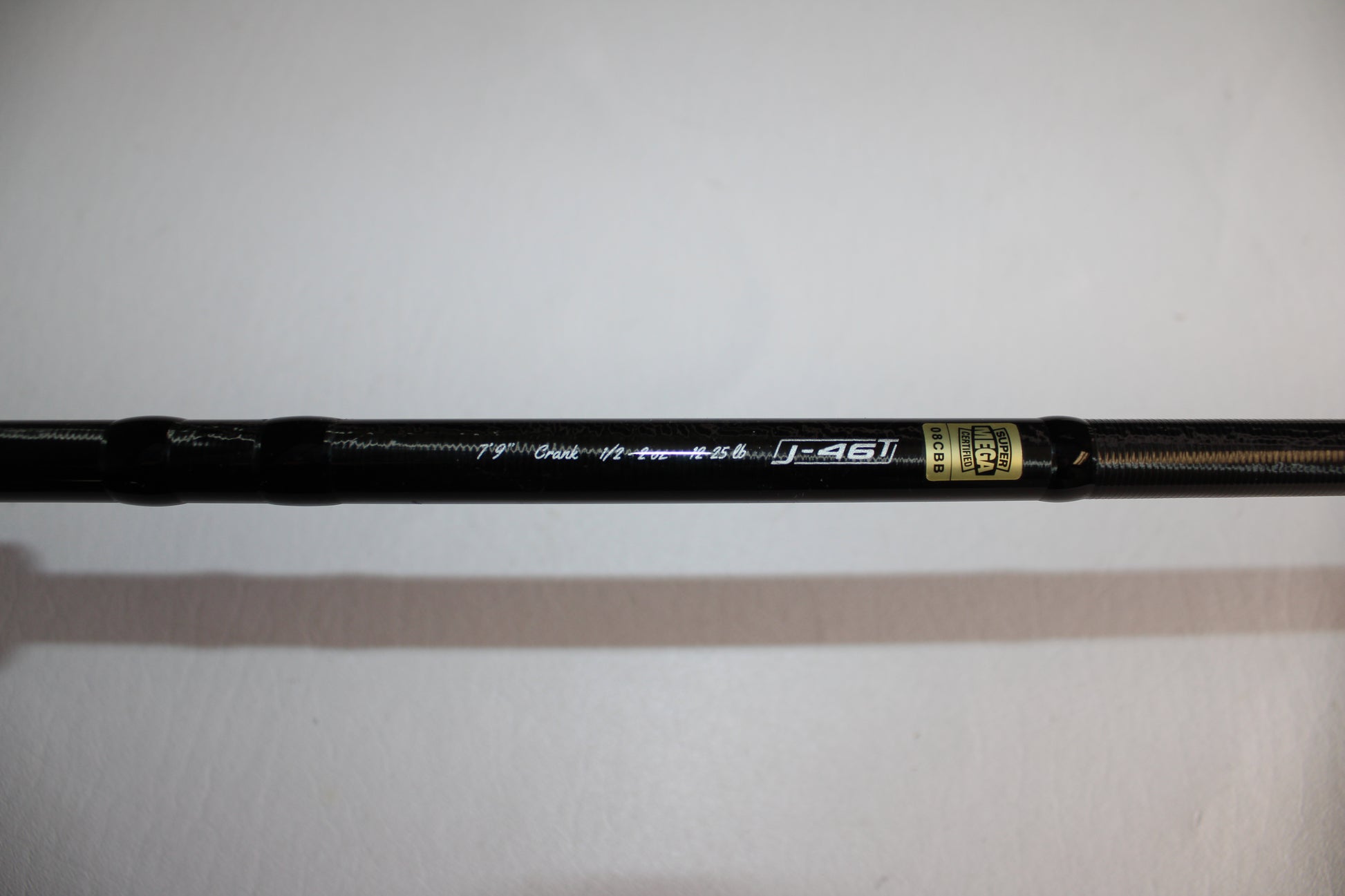 A close-up of a 13 Fishing Envy Black EB3C79C Crank casting rod in good used condition, featuring metallic "j-46T" text and a gold label on a white background.