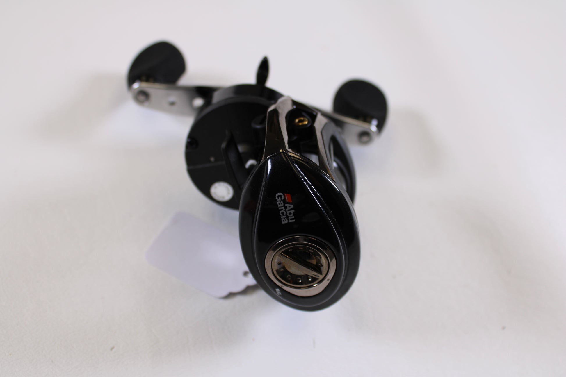 An Abu Garcia Revo Winch Gen 2 5.4:1 RH used casting reel in excellent condition is shown on a white surface from a slightly elevated angle—ideal for those seeking savings through our Rod and Reel Trade-In Program.