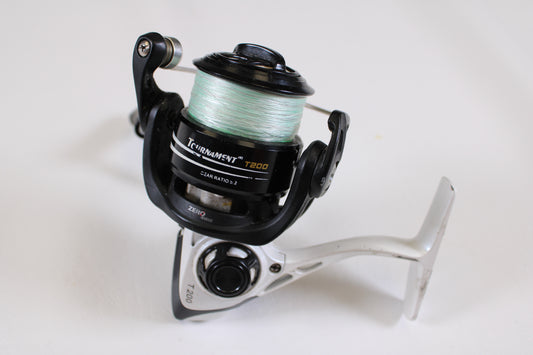 A close-up of a Lew's Tournament Speed Spin T200 5.2:1 spinning reel in fair condition with spool clicks, shown with green line on a white background—ideal for trade-in or adding to your used fishing gear collection.