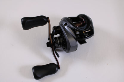 A close-up of an Abu Garcia Revo SX REVO5 SX LP 6.7:1 RH Used Casting Reel in excellent condition with two ergonomic handles, shown on a white surface—ideal for our Rod and Reel Trade-In Program if upgrading your gear.
