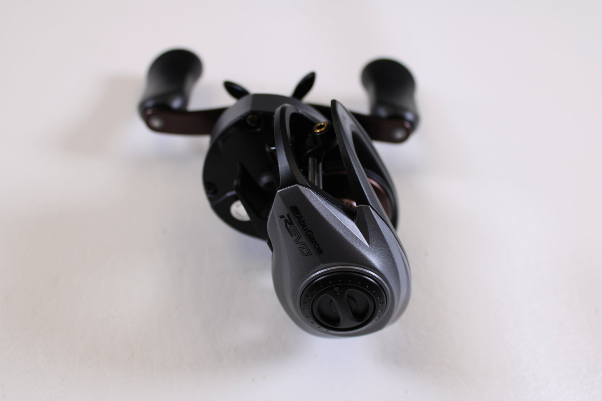 A close-up of an Abu Garcia Revo SX REVO5 SX LP 6.7:1 RH Used Casting Reel in excellent condition, showcasing its handle and adjustment knobs, possibly featured in our Rod and Reel Trade-In Program.