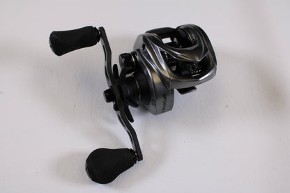 A close-up of a Kistler Chromium 7.3:1 RH—Used Casting Reel in excellent condition, featuring padded handles on a white surface—ideal for our Rod and Reel Trade-In Program to earn store credit with quality used Kistler gear.