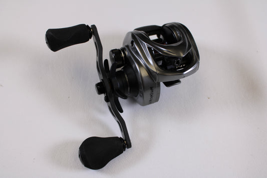 A close-up of a Kistler Chromium 7.3:1 RH—Used Casting Reel in excellent condition, featuring padded handles on a white surface—ideal for our Rod and Reel Trade-In Program to earn store credit with quality used Kistler gear.
