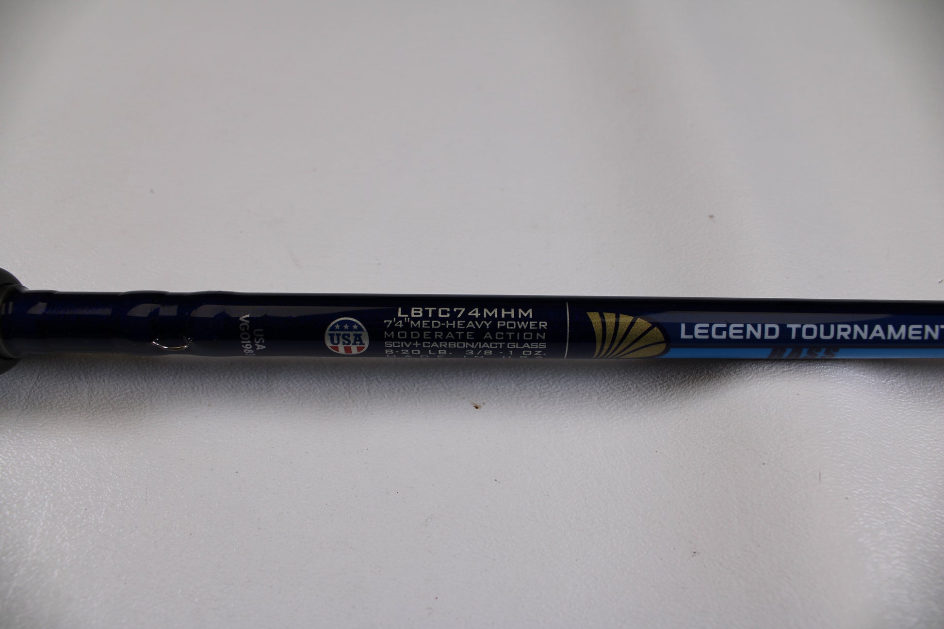 Close-up of a blue St. Croix Legend Tournament Bass LBTC74MHM Power Glass Cranker 7'4" Med-Heavy Casting Rod, Used in Excellent Condition, with "MODERATE ACTION" and USA logo visible on a white background.