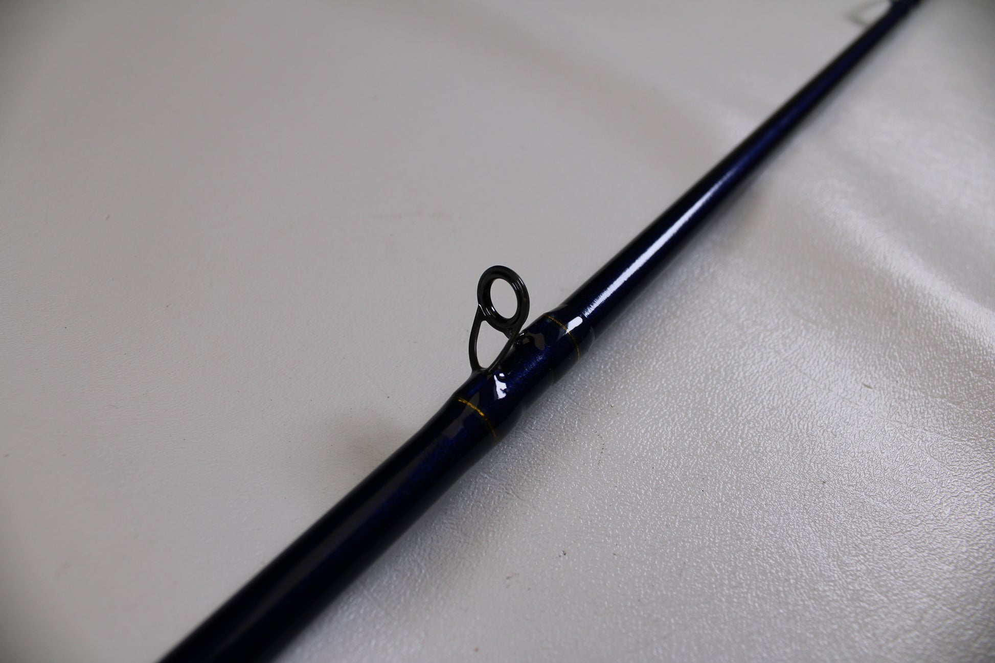 A close-up of the St. Croix Legend Tournament Bass LBTC74MHM Power Glass Cranker 7'4" Medium Heavy Used Casting Rod in excellent condition shows a single line guide ring, resting on a light surface—ideal for our Rod and Reel Trade-In Program.
