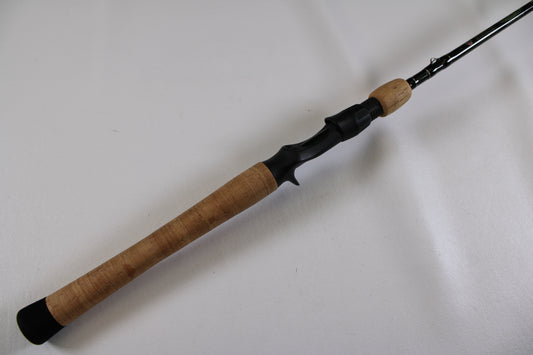 A close-up of the St. Croix Legend Elite EC70MF 7'0" Medium used casting rod’s cork grip and black reel seat on a white background—ideal for our Rod and Reel Trade-In Program.