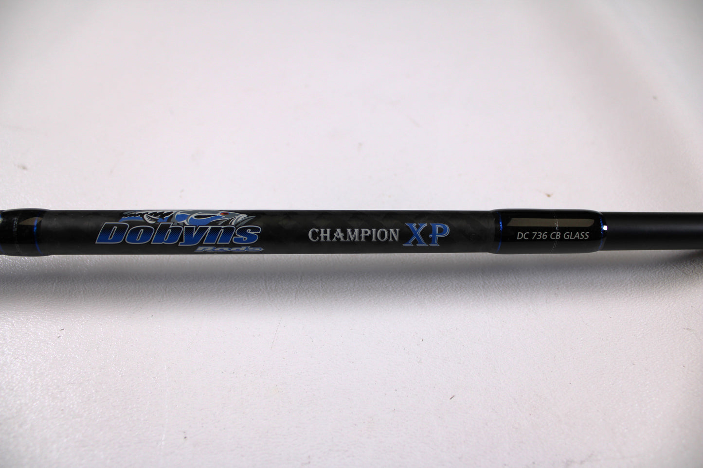 Close-up of a Dobyns Champion XP DC736CBGLASS 7'3" Heavy Used Casting Rod in very good condition, available through our Rod and Reel Trade-In Program for store credit on used gear, shown against a white background.
