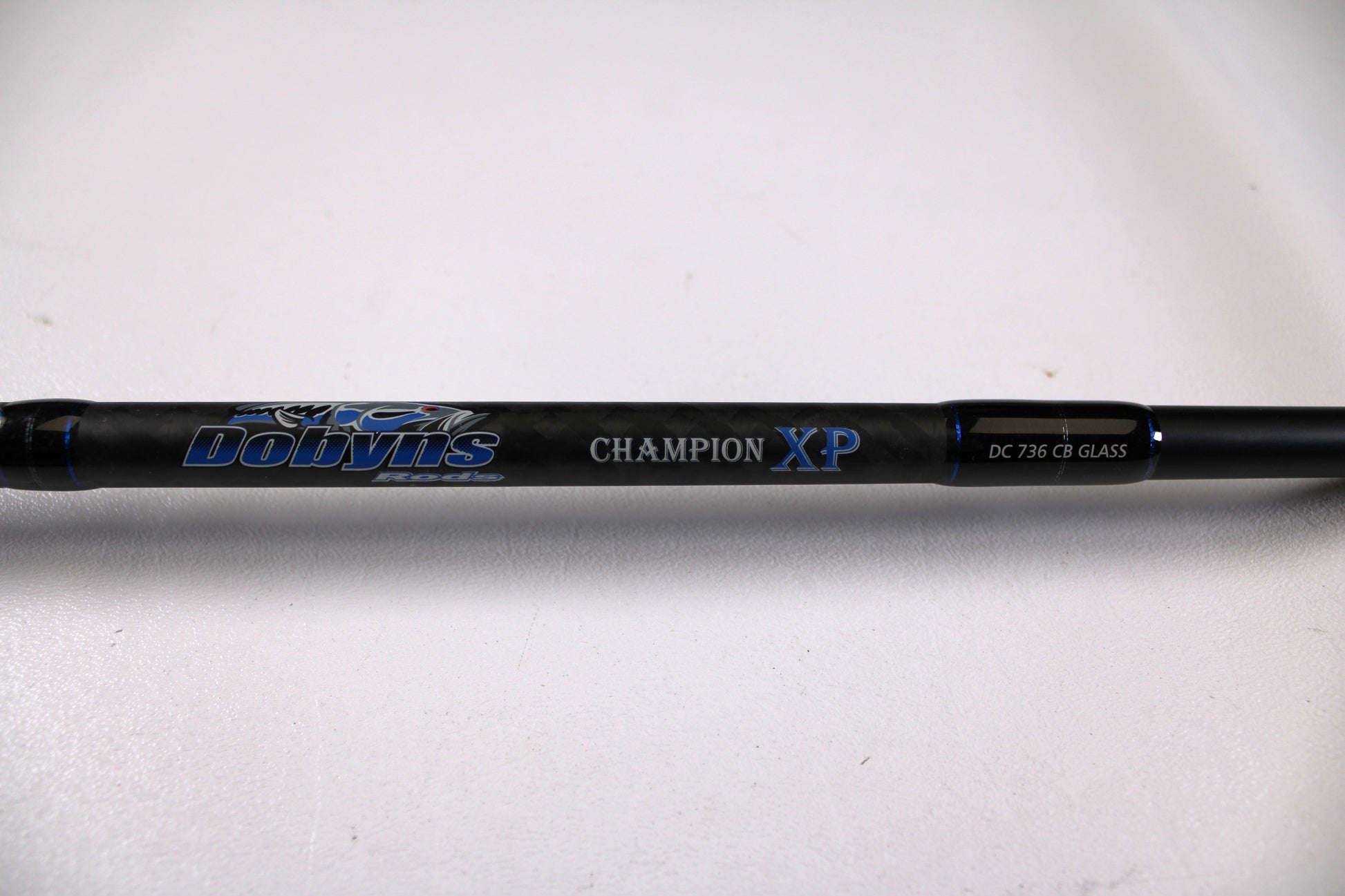 Close-up of a Dobyns Champion XP DC736CBGLASS 7'3" Heavy Used Casting Rod in very good condition, available through our Rod and Reel Trade-In Program for store credit on used gear, shown against a white background.