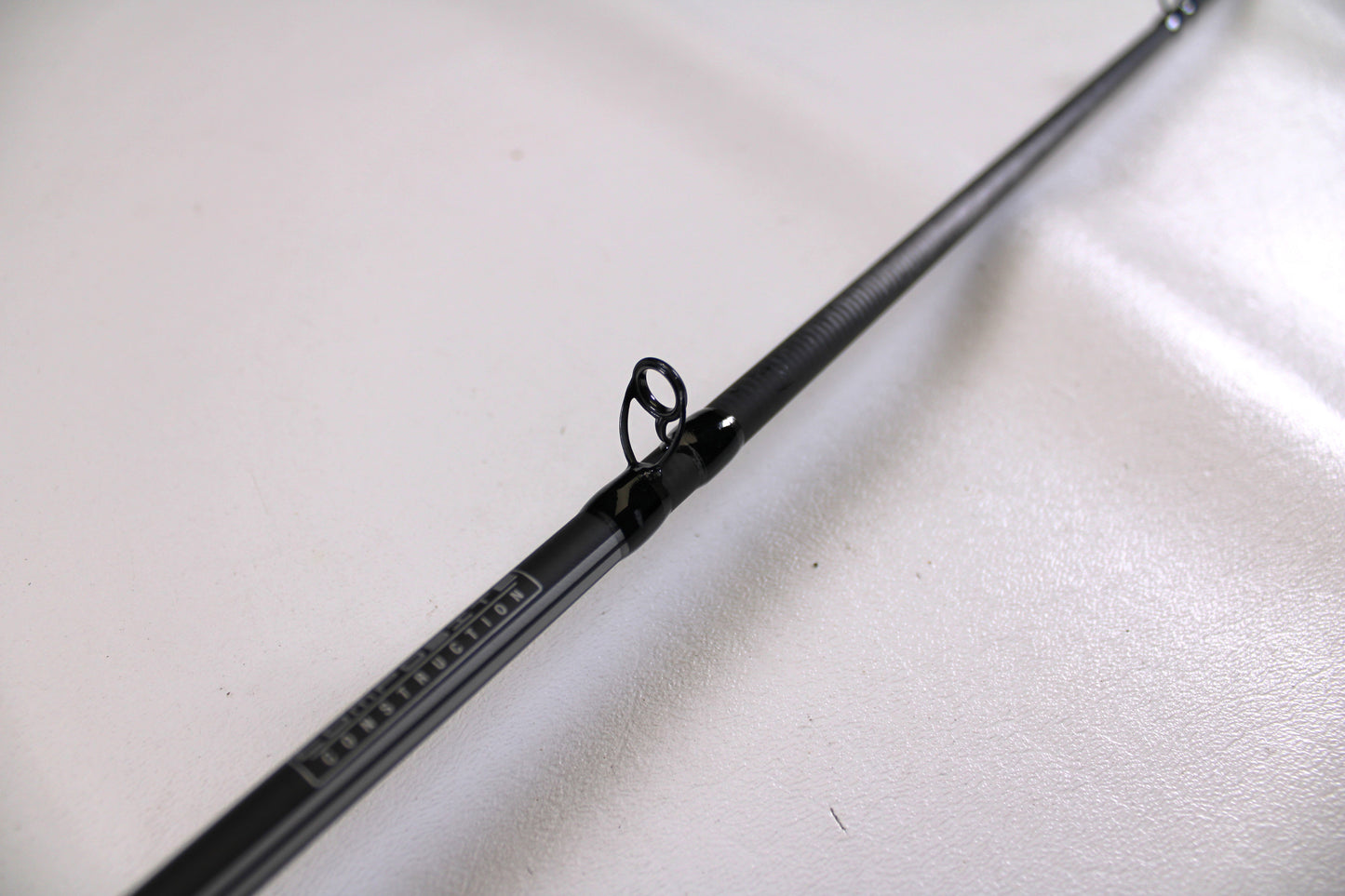 Close-up of a used Abu Garcia Winch WINCHC70-5 7'0" Medium Casting Rod in excellent condition, highlighting a line guide—perfect for the Nation's Best Rod and Reel Trade-In Program.