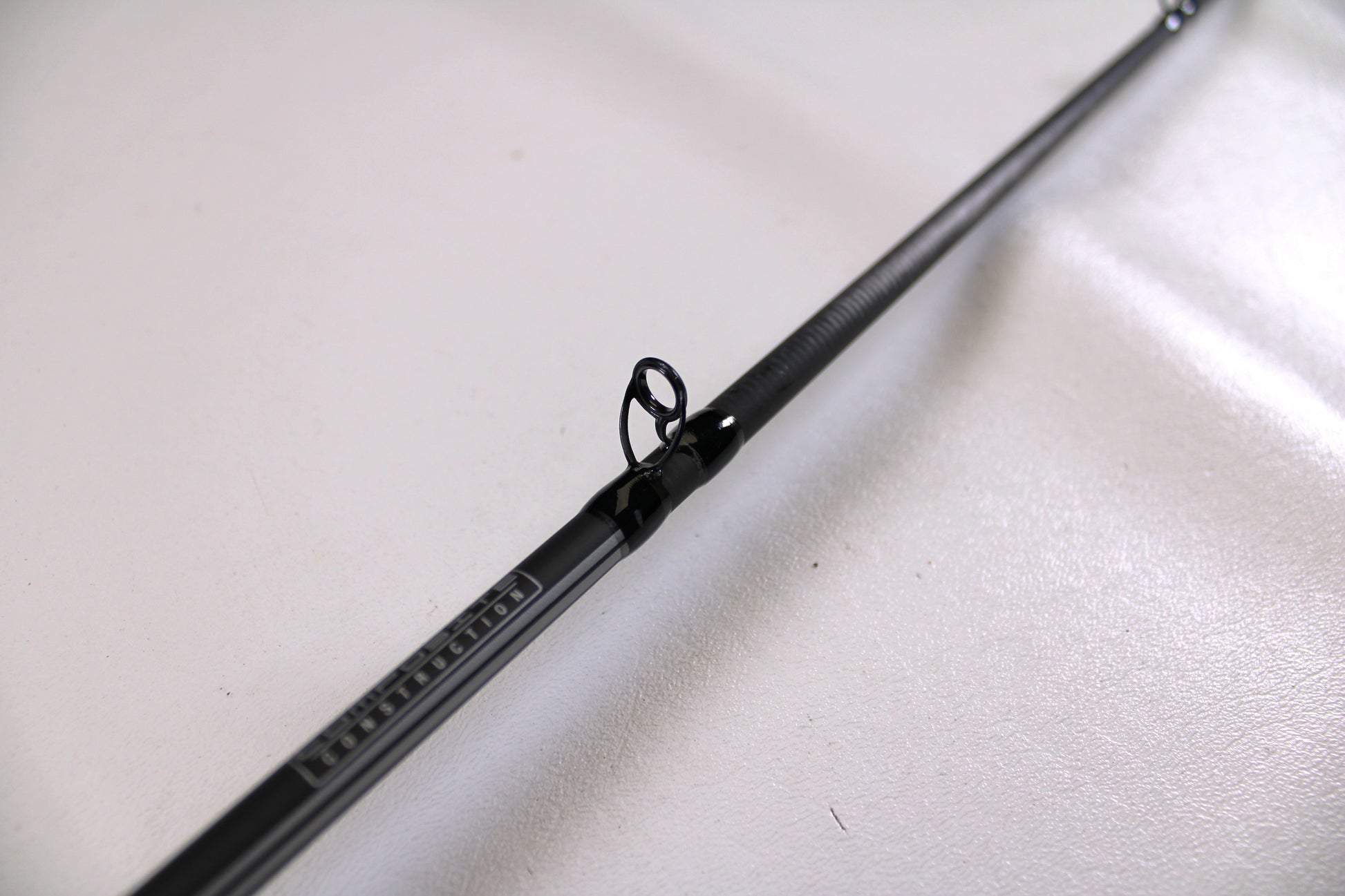 Close-up of a used Abu Garcia Winch WINCHC70-5 7'0" Medium Casting Rod in excellent condition, highlighting a line guide—perfect for the Nation's Best Rod and Reel Trade-In Program.
