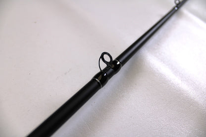 A detailed close-up of the Enigma Ippon EIPN7MB-MH 7'0" Medium Heavy Used Casting Rod in Excellent Condition, highlighting a guide ring against a white background—ideal for assessing used gear for our Rod and Reel Trade-In Program.