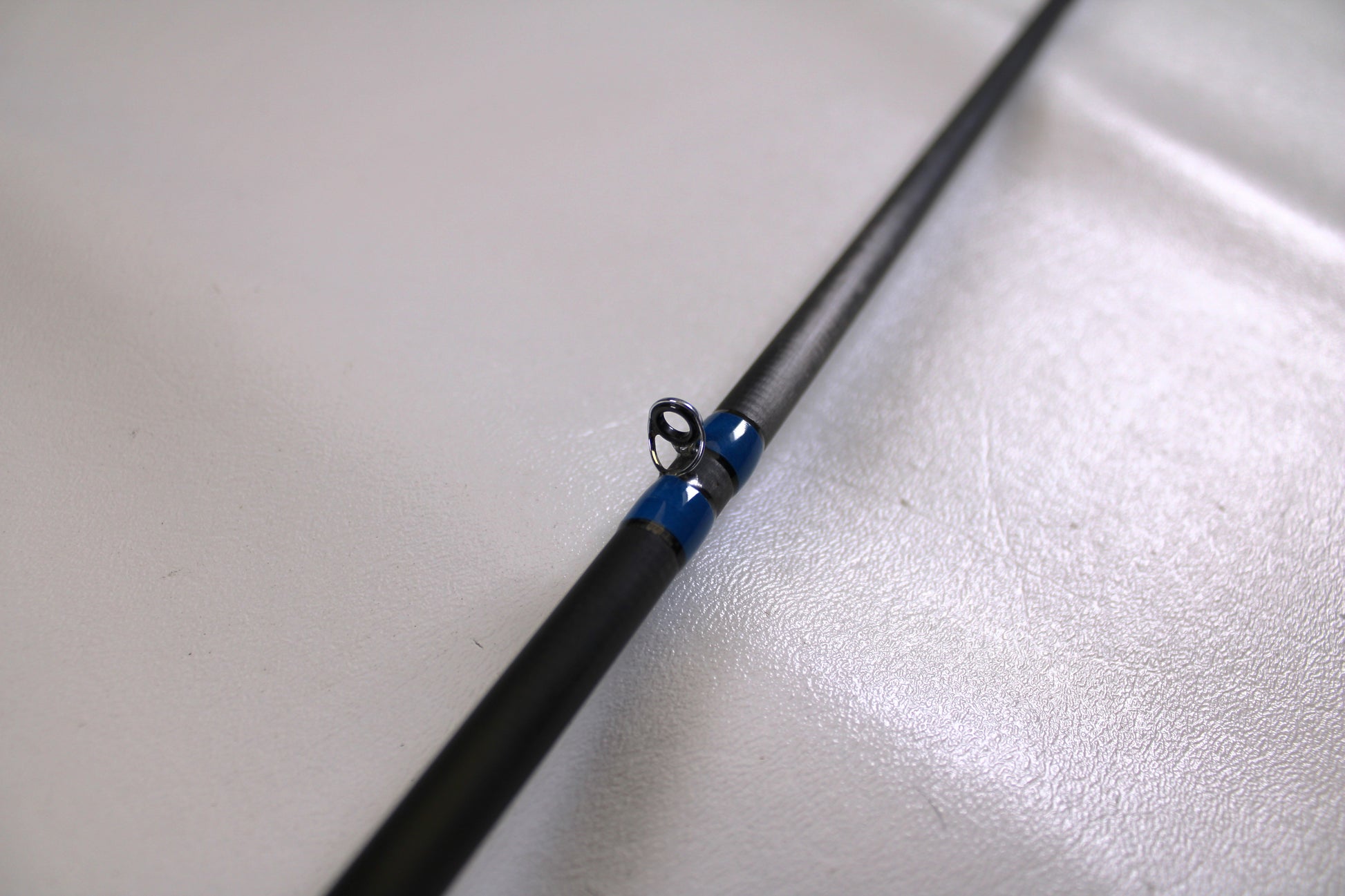 A close-up of the Alpha Angler Slasher 6'10" Medium Used Casting Rod in excellent condition, highlighting a blue-wrapped line guide—ideal for those seeking quality used gear or exploring rod and reel trade-in options.
