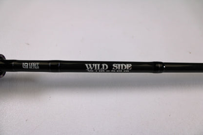 A close-up of a black Legit Design Wild Side WSC 610MH 6'10" Medium Heavy casting rod in excellent used condition, featuring white "WILD SIDE," "Take a walk on the wild side," and "LEGAL DESIGN" text. Trade in your gear for store credit.