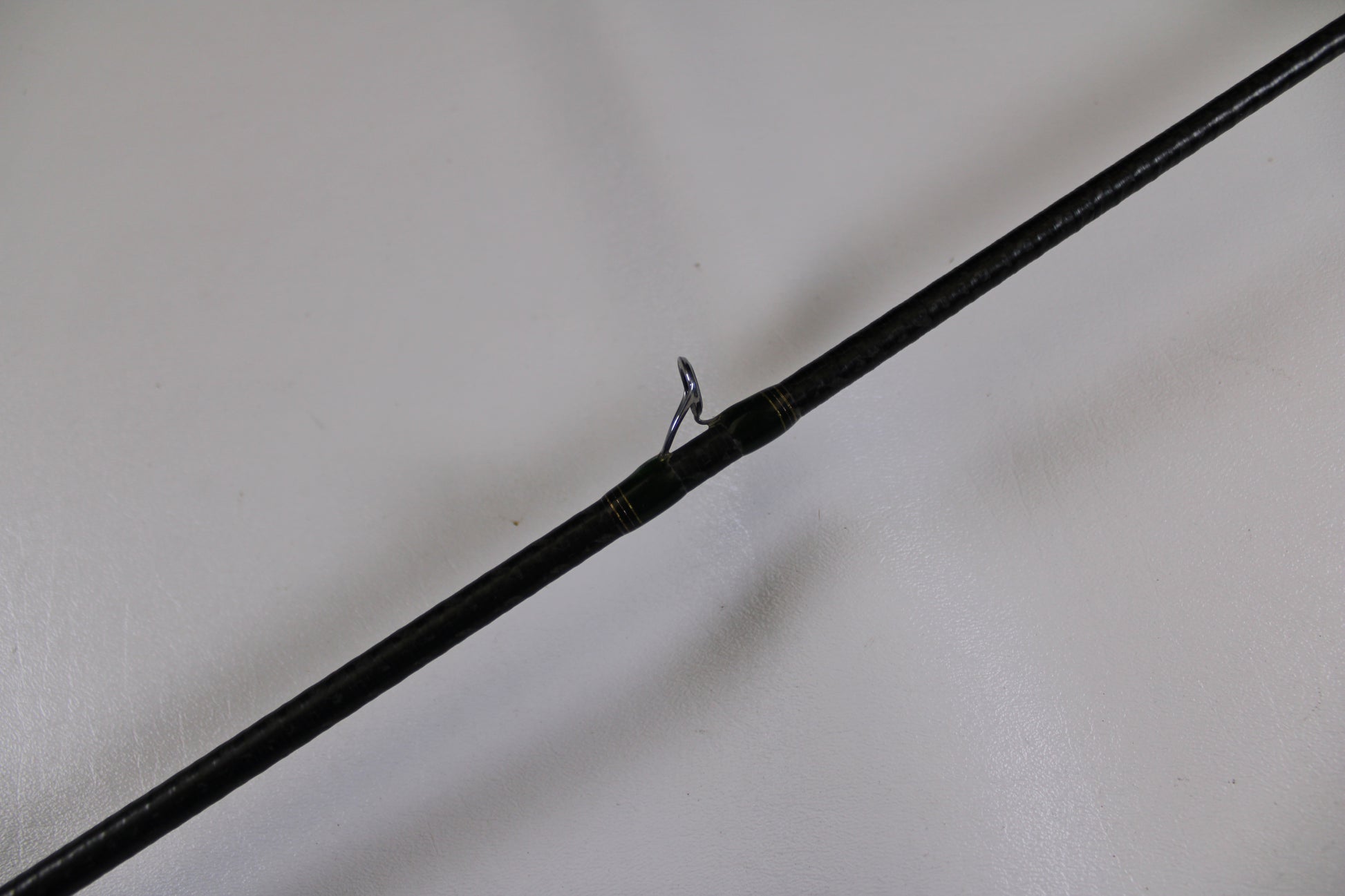 A close-up of a Megabass Orochi XX Aaron Martens F4.1/2-68XX Jerkbait Special used casting rod in fair condition highlights a single metal guide ring—ideal for those interested in used gear or our Rod and Reel Trade-In program.