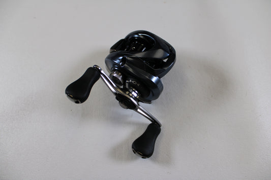 A Shimano Aldebaran MGL ALDMGL50HG used casting reel in excellent condition, featuring black and silver design and two handles, is displayed on a plain white surface—perfect for upgrading your gear or a Rod and Reel Trade-In.