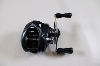 A close-up of a Shimano Aldebaran MGL ALDMGL50HG used casting reel in excellent condition, set on a white surface—ideal for upgrading with our Rod and Reel Trade-In or buying quality Shimano gear with store credit.