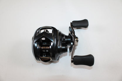 The Daiwa Tatula SV 70 TTUSV70XH Used Casting Reel—black with dual handles and a compact metallic design—is shown on a white background, ideal for trade-ins or store credit through our Rod and Reel Trade-In Program.