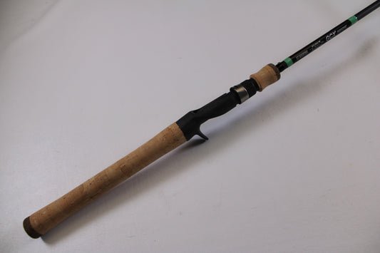 A close-up of the G. Loomis GCX Inshore 842C MF Used Casting Rod in excellent condition, featuring a cork handle and black reel seat—ideal for those considering our Rod and Reel Trade-In Program.