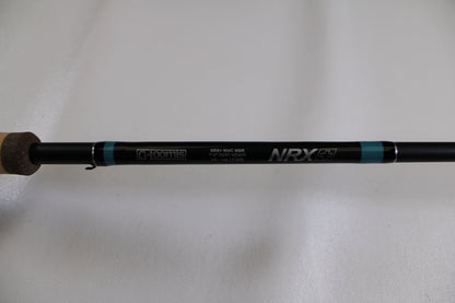 A close-up of a G. Loomis NRX+ 904C MBR Used Casting Rod in excellent condition, showing cork handle and brand logos on the black rod against a plain white background.