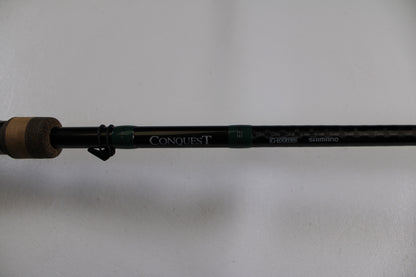 Close-up of the G. Loomis Conquest CNQ 905C MBR Used Casting Rod in very good condition, showing "CONQUEST" and "G.Loomis" logos on the black shaft with cork handle—ideal for our Rod and Reel Trade-In Program or for store credit.