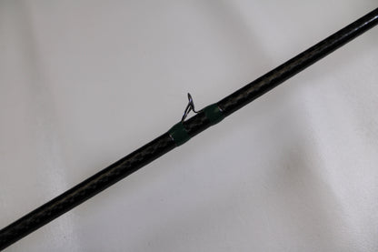 A close-up of the G. Loomis Conquest CNQ 905C MBR Used Casting Rod in very good condition, featuring a black finish and green-threaded line guide—ideal for trading in through our Rod and Reel Trade-In Program.